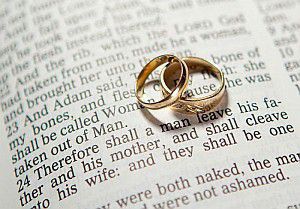 Two Gold Wedding Bans Stacked on Page of Bible